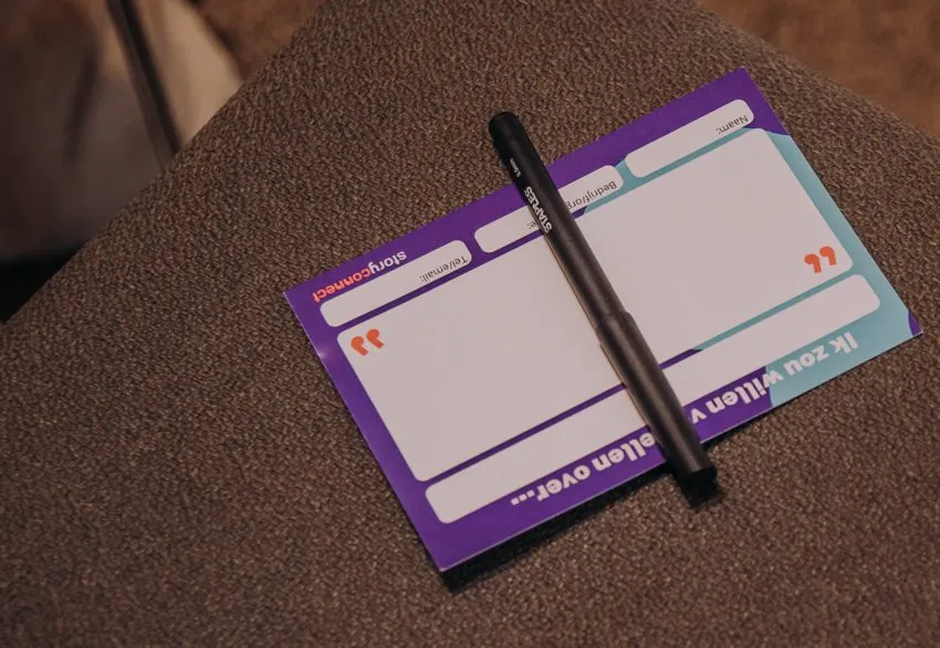Een vertelkaartje van StoryConnect met een pen