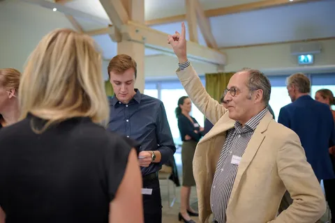 Man steekt zijn vinger op tijdens een gesprek in de zaal
