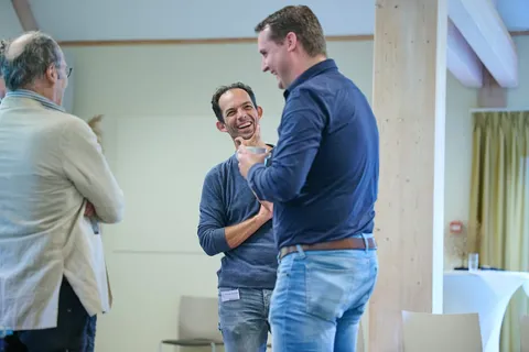 Twee mannen lachen samen tijdens een informeel gesprek