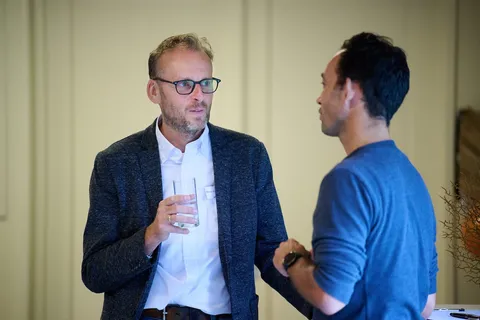 Man met een glas water in gesprek met een collega