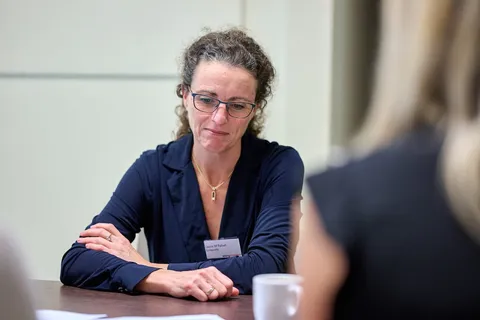Vrouw luistert nadenkend aan tafel tijdens een gesprek