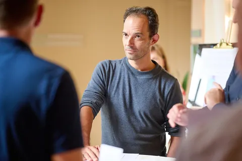 Man luistert aandachtig tijdens een gesprek in de zaal