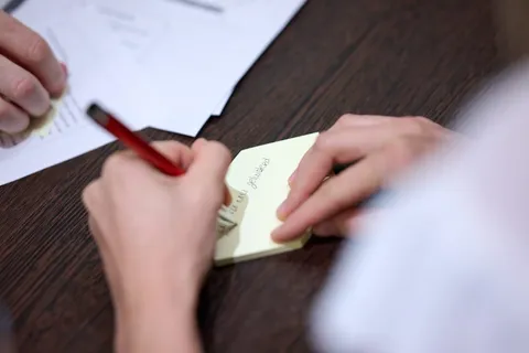 Deelnemer schrijft een tekst op een geel memoblaadje